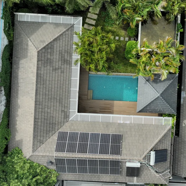 The plot from above: the L-shaped house, the pool with its sala, the garden, and the solar panels on the roof